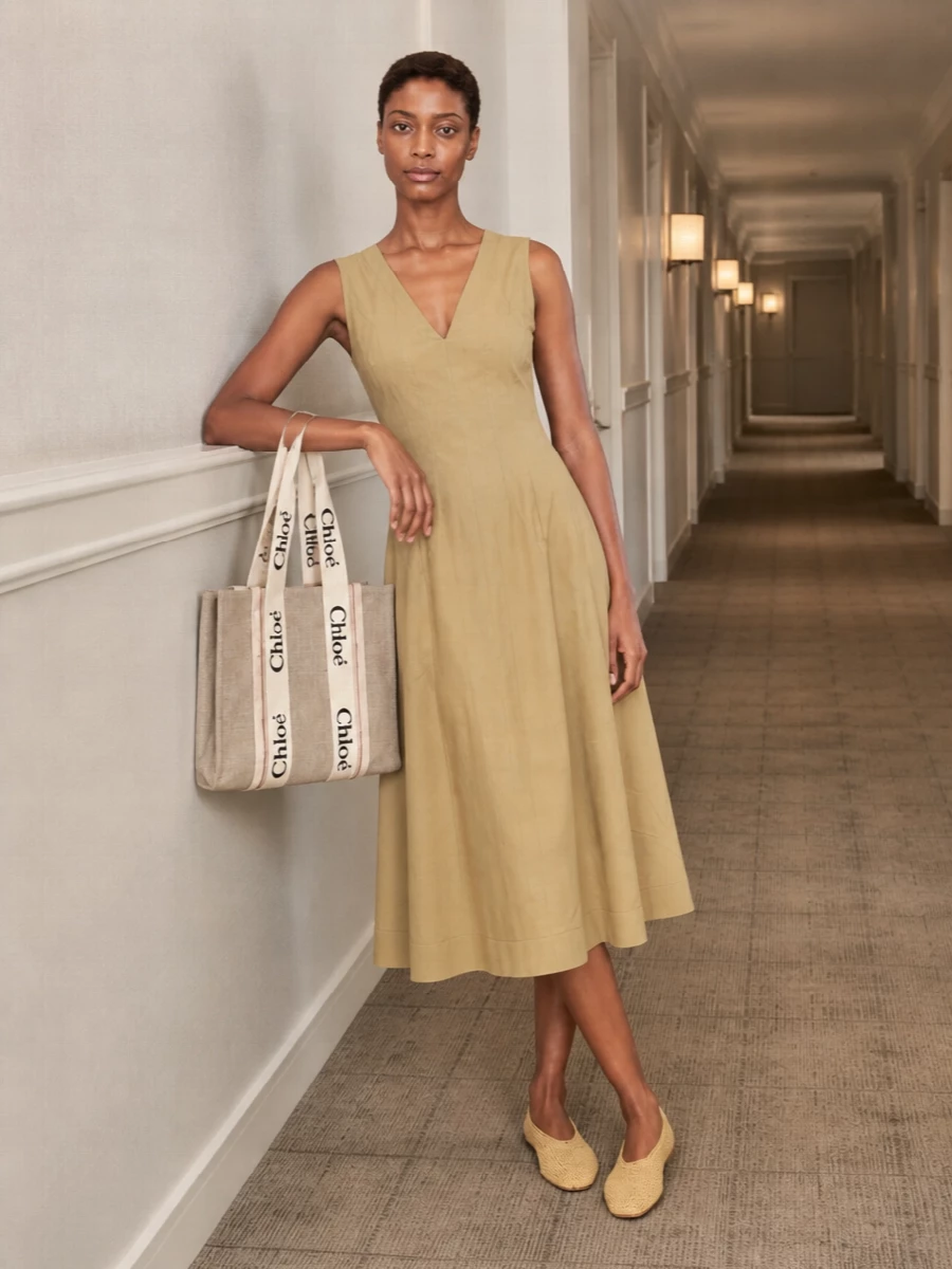 Choosing the sand midi dress over separates keeps the focus on pure, elongated lines and lets the Chloé tote feel intentional rather than just practical. The warm beige-on-beige story, from structured canvas bag to soft woven flats, feels like relaxed summer tailoring with a gentle boho undercurrent. It is the kind of quiet, neutral column you can wear from market mornings to late terrace dinners with nothing more than jewelry changes.