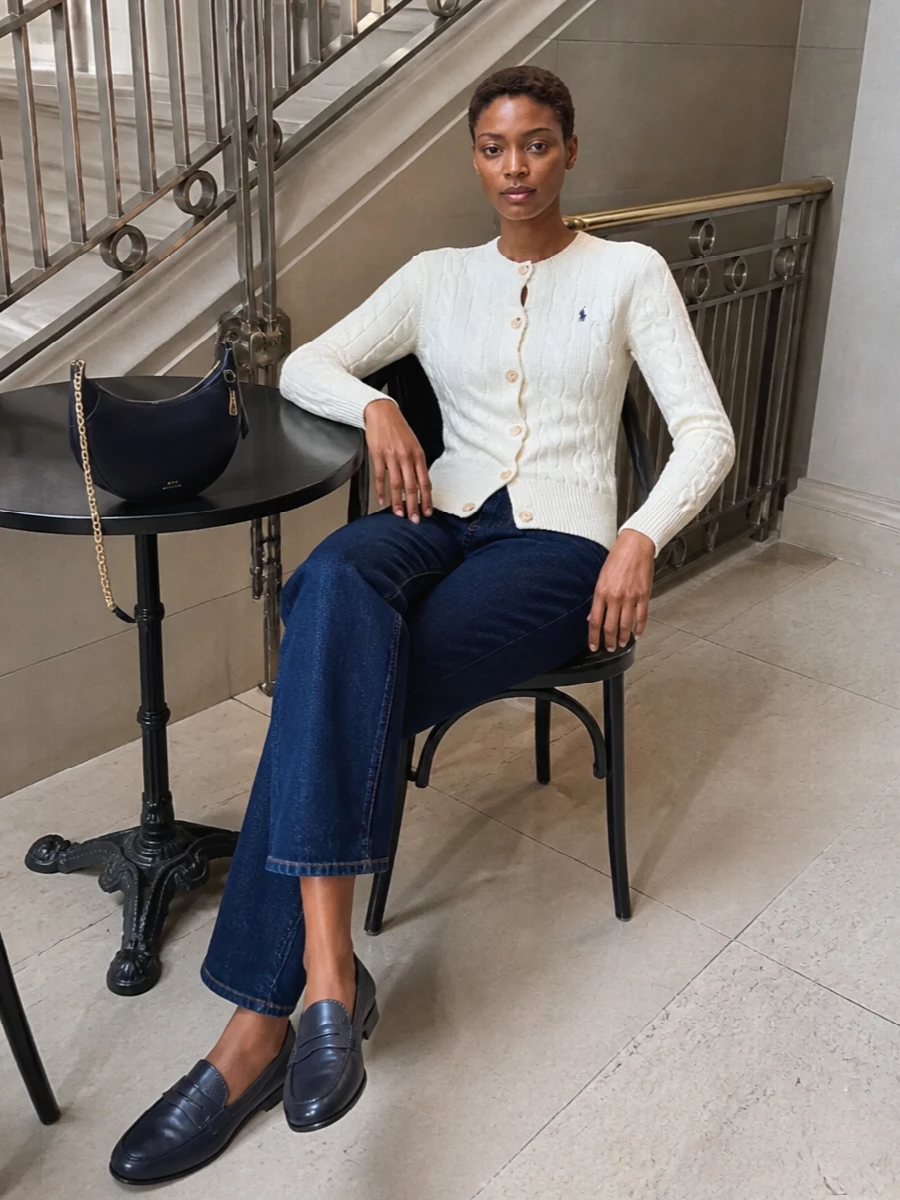 Cream cable knit, dark indigo denim and navy leather pieces come together in a quietly polished, East Coast prep mix. The proportions stay clean and regular, so the interest is all in the textures and subtle logo notes. It feels right for coffee runs that turn into a full city day, neat enough for casual meetings but relaxed in attitude.