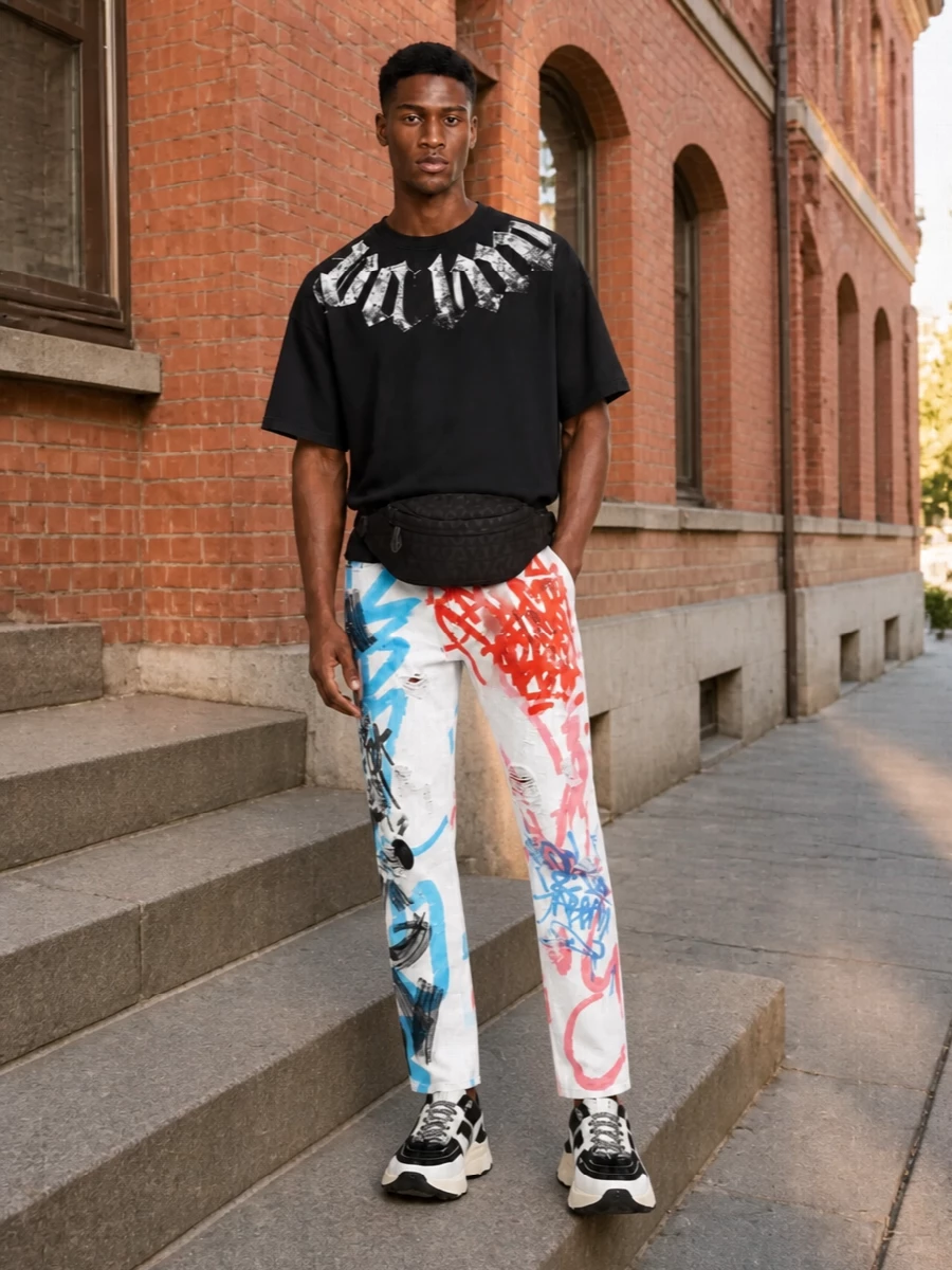Dolce & Gabbana’s graffiti denim stays front and center, grounded by a washed black Palm Angels tee that keeps the attitude sharp but unfussy. Chunky Valentino runners echo the graphic black and white story, giving the whole outfit a clear sport edge. The quilted belt bag finishes it with just enough logo polish while keeping everything mobile and night-out ready.