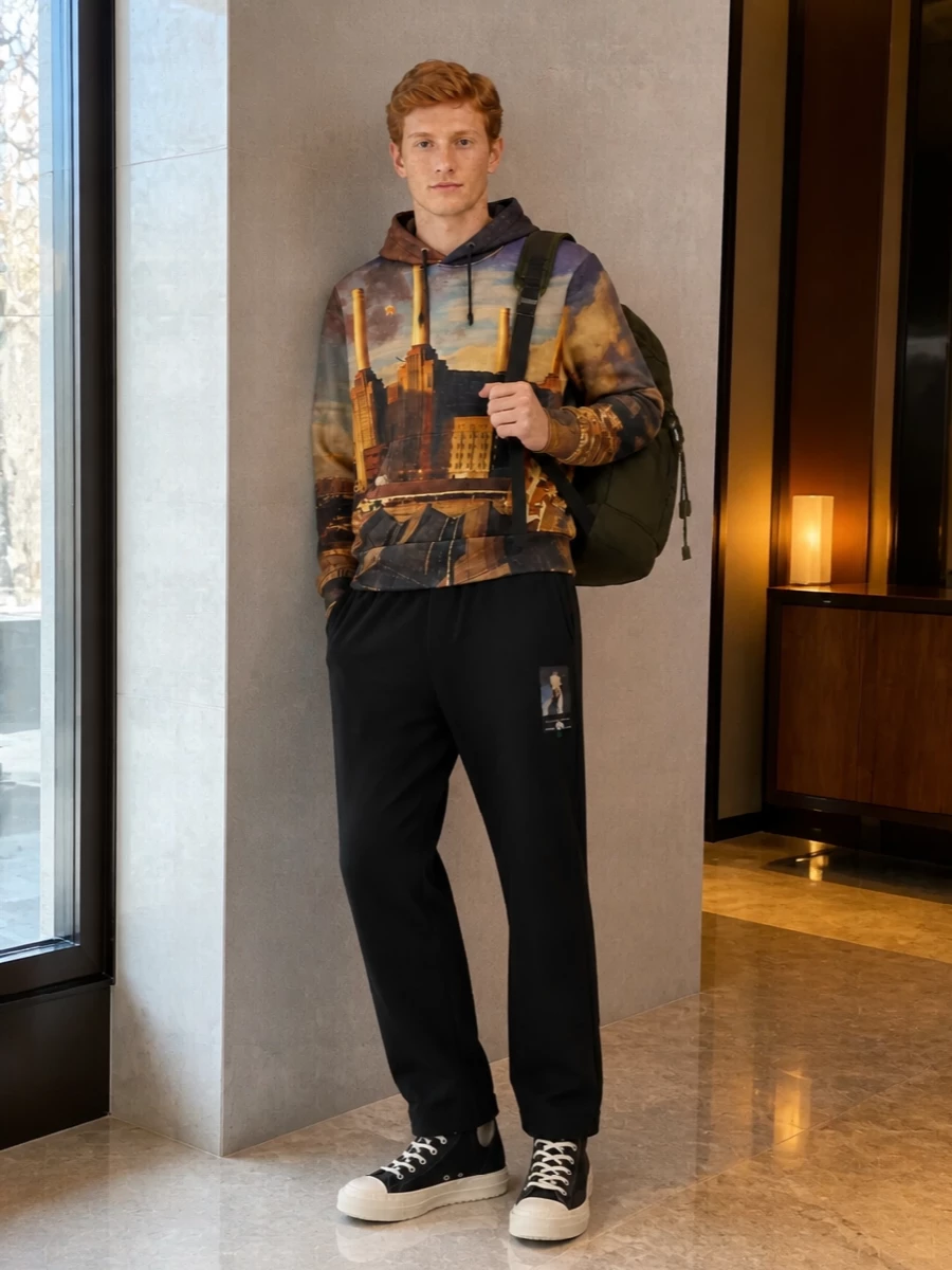 Undercover’s skyline hoodie sits over clean black straight-leg trousers for a relaxed, intelligent streetwear uniform. Black DRKSHDW high-tops keep the line graphic and unfussy, while the dark olive Prada backpack leans into a technical city-commuter mood without fighting the print.