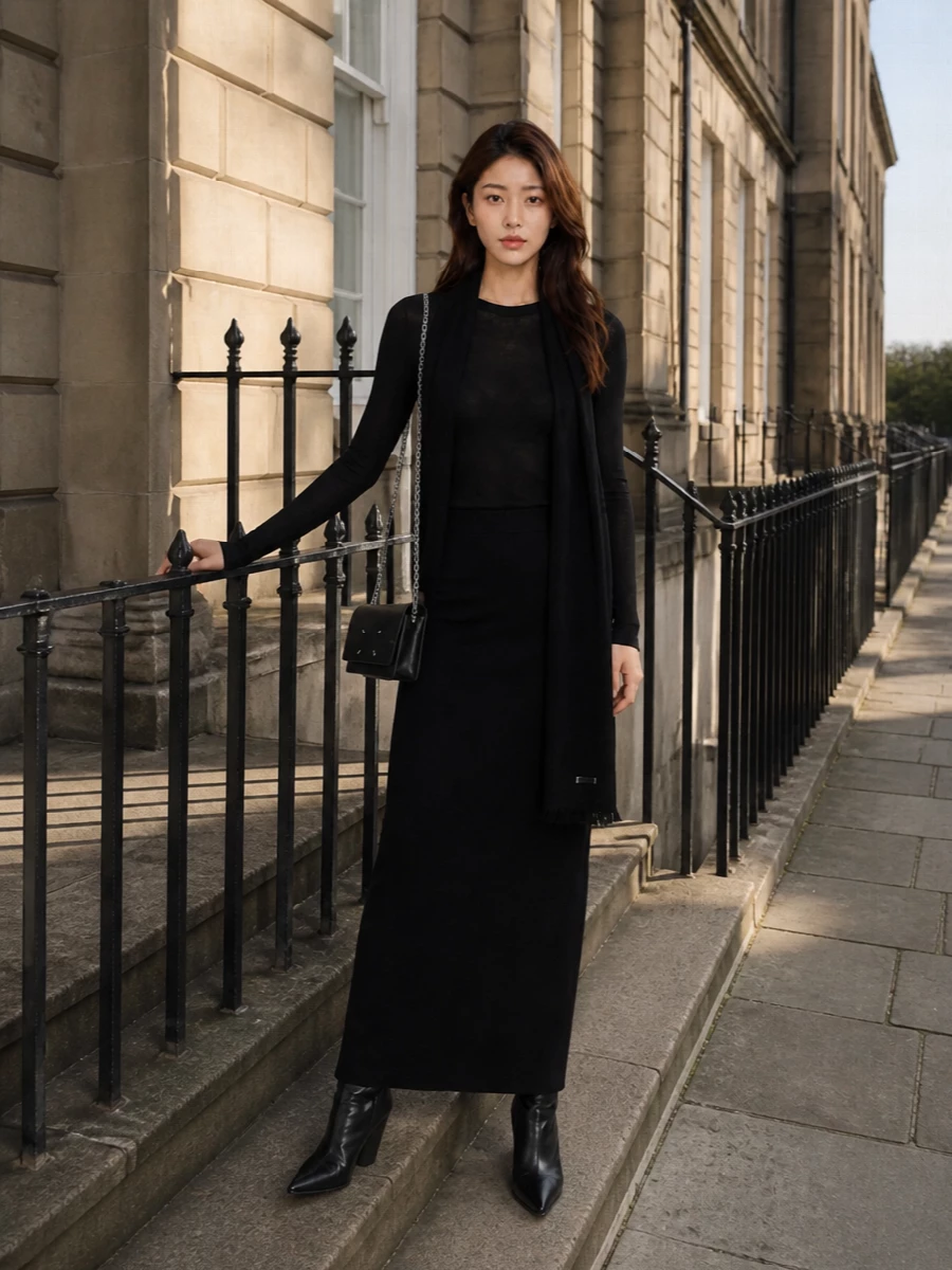Head-to-toe black becomes a single, uninterrupted column here, with the gauzy Rick top melting into the dense knit skirt. Sculptural wedge boots and a compact Margiela chain crossbody sharpen the line, while a long black scarf exaggerates the vertical for a quietly brutalist city uniform. It is dark, minimal and subversive enough to feel like night armor without losing ease or movement.