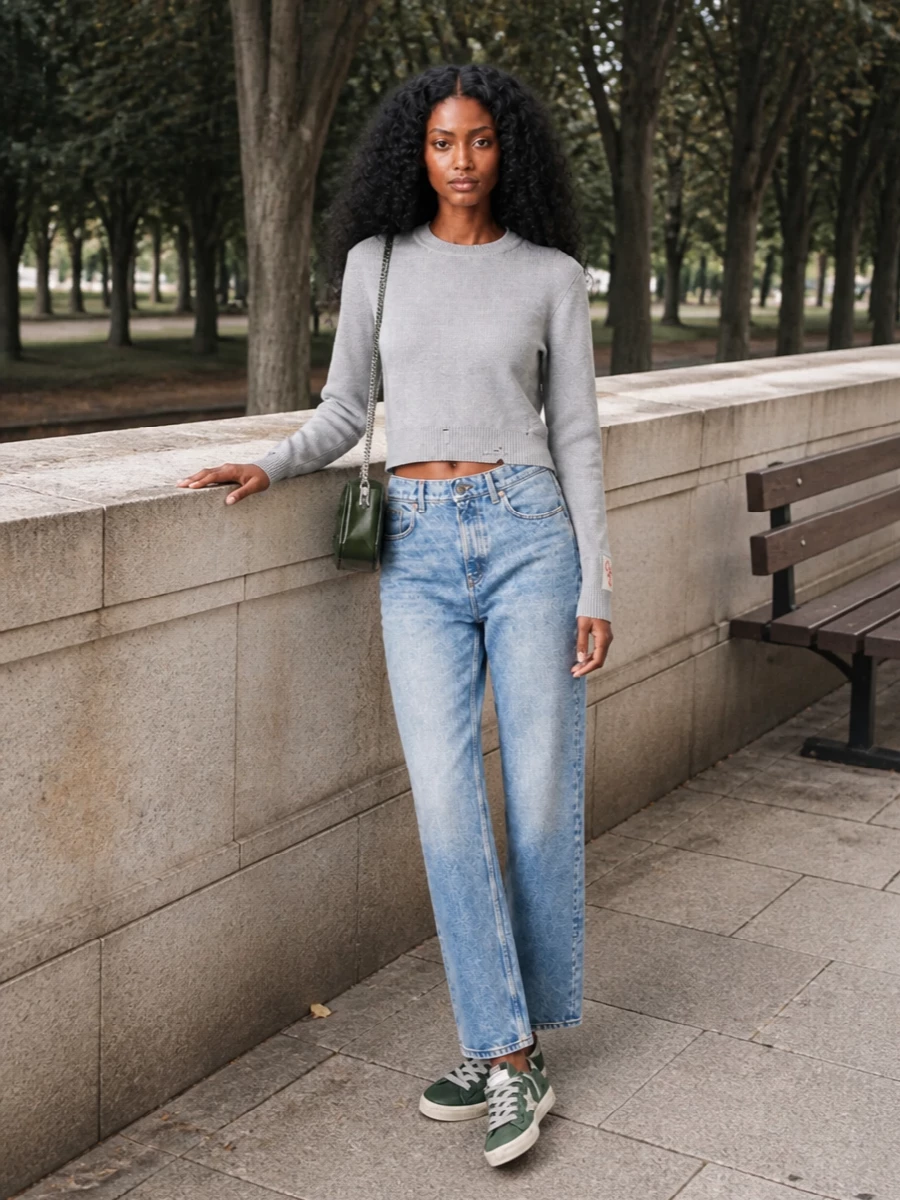This is a soft-grunge city uniform built around light denim, a cropped grey knit and those lived-in green Golden Goose sneakers. The high-rise straight jean grounds the proportion so the subtle crop on the sweater feels intentional rather than cute. The glossy olive crossbody pulls in the sneaker green and silver, tying the palette together while keeping everything firmly in off-duty territory.