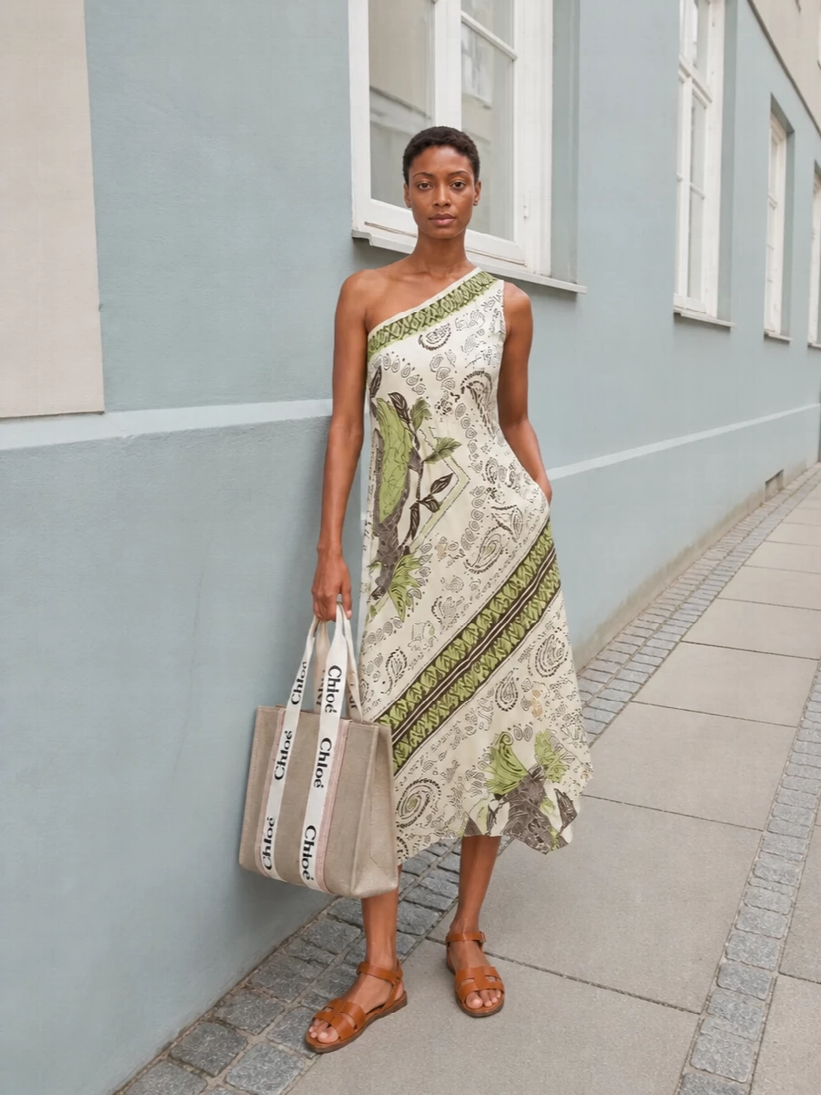 Leaning into the tote’s relaxed Parisian energy, the one-shoulder paisley midi becomes the hero, bringing a sun-faded boho note that still reads refined. The tan caged sandals keep the mood grounded and relaxed, balancing the dress’s movement while sitting perfectly in the same warm, neutral family as the Chloé tote. Choosing the dress route over separates lets the print and asymmetry do the talking, for an uncomplicated summer outfit that still feels considered and multi-occasion.