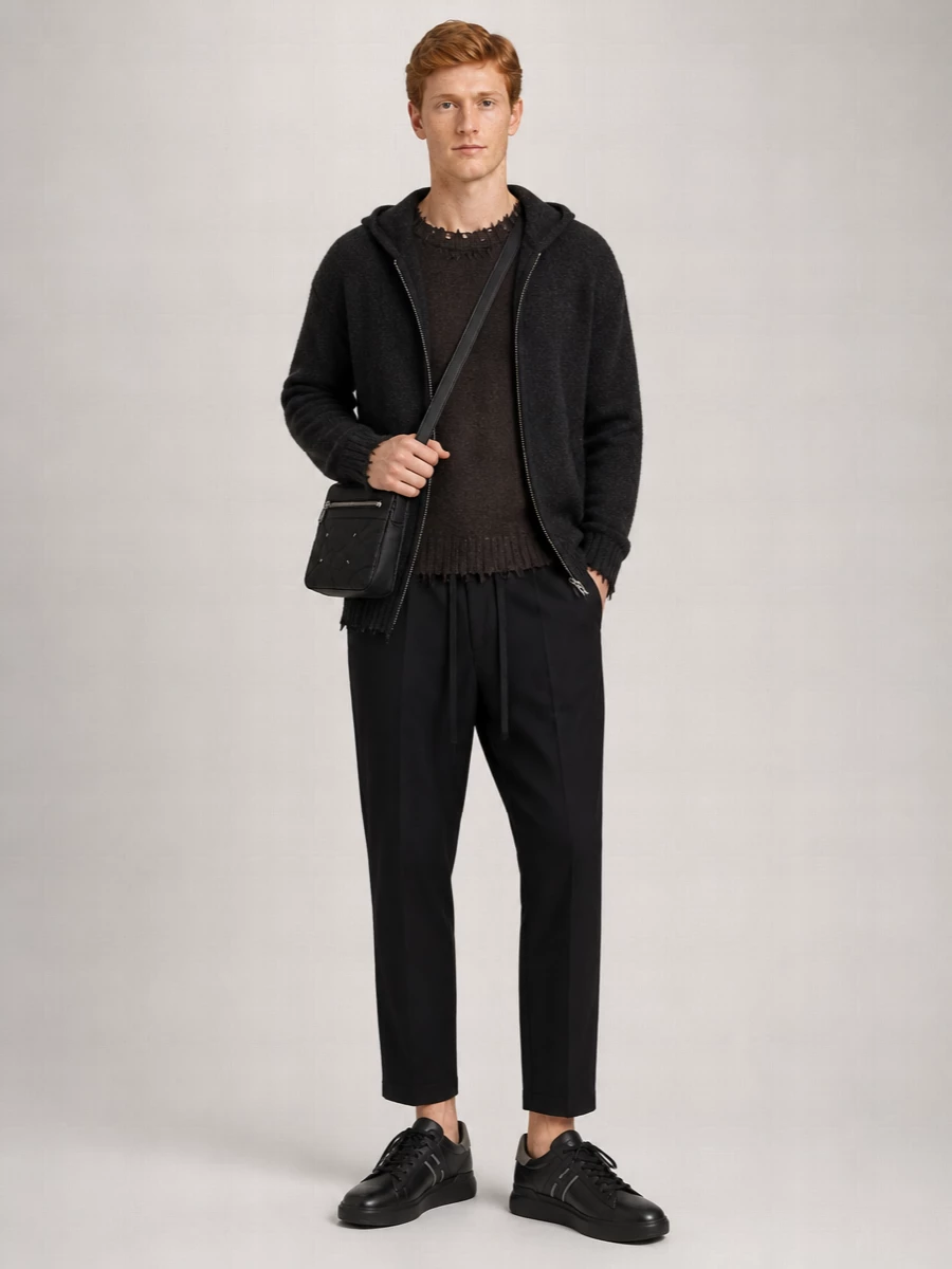 Charcoal and deep espresso tones keep this layered Uma Wang hoodie and knit pairing quietly intense, while the cropped tailored trouser sharpens the relaxed volume. Sleek black Hogan sneakers and a padded Margiela crossbody hold the line between off-duty and composed, giving the whole outfit a considered city edge. It is a winter uniform for someone who likes their comfort with just enough structure and nuance.