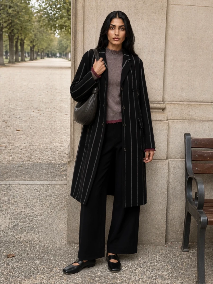 I am building around the coat as outerwear, so I chose the top and trouser route rather than a dress to honour its tailored, everyday-intellectual energy. The mauve taupe knit and black wide-leg trouser create a long, calm column under the striped coat, with the square-toe ballerinas and sculpted crescent bag keeping everything moody, polished and quietly artistic for city winter days. It feels like Uma Wang in full, poetic tailoring mode without tipping into occasionwear.