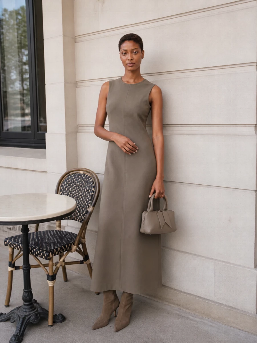 The sleeveless taupe column dress is the right anchor here, echoing the Aquazzura boots’ streamlined pointed toe and staying within a single, refined neutral story. Together they create a long, uninterrupted silhouette that feels ideal for warm evening dinners or gallery openings. The compact taupe top-handle bag finishes the outfit with quiet structure without breaking the minimalist flow of the line.