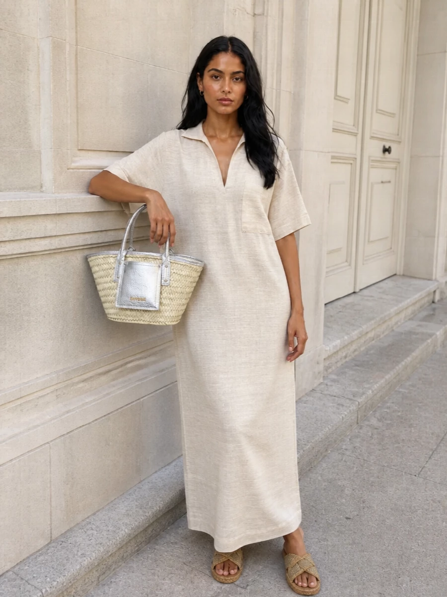 I chose the dress route, as the soft oat maxi creates a single, elongated canvas that really lets the Jacquemus basket bag be the focus without competing cuts or prints. Together with the woven tan slides, it reads like a polished beach-to-city uniform in sun-faded neutrals that quietly pick up the bag’s straw and silver tones. The result is relaxed but considered, ideal for warm days when you want ease and a subtle sense of occasion around that basket bag.