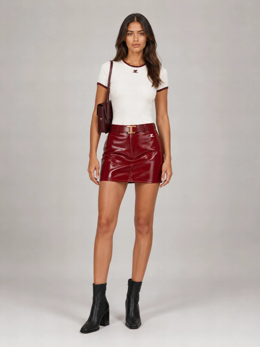 Courrèges’ logo tee meets its match in a deep red vinyl mini, the shared burgundy tones making the set feel intentional rather than nostalgic. Black sock boots ground the shine with a sleek, elongating line, while a bordeaux shoulder bag and slim burgundy belt quietly refine the palette. The result is a minimal, slightly Y2K city uniform that reads polished but still playful enough for late afternoons that drift into evening.