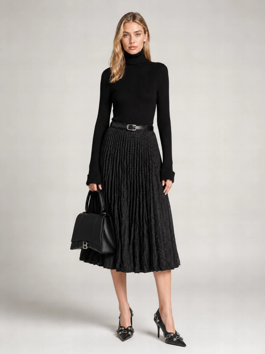 A monochrome Balenciaga uniform that feels clean, directional and quietly assertive. The close black knit carves out the waist against the crushed pleats, while pointed heels and a structured bag add precise, hardware-driven polish. It reads city-ready from desk to late dinner without losing the skirt’s movement and attitude.