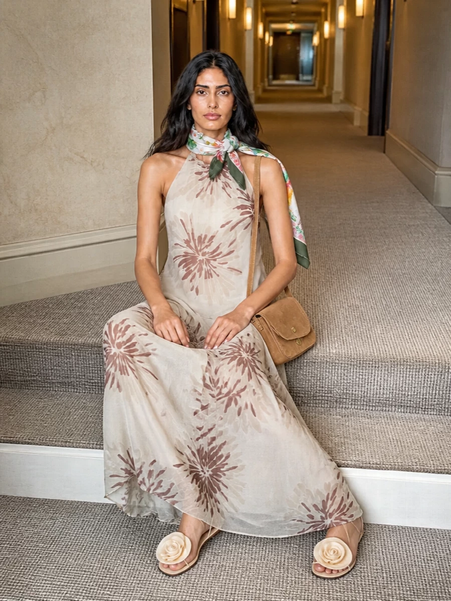 I chose the dress path because the Brunello Cucinelli floral halter maxi and Gucci scarf together create a single, romantic statement where additional separates would overcomplicate the print and soften the quiet-luxury mood. The buttercream floral sandals and small camel suede bag stay tonally in the warm cream and taupe family, letting the mix of florals read cohesive and intentionally garden-party rather than busy. Think sunlit terrace cocktails or a summer wedding guest moment, with the scarf knotted at the neck or draped over bare shoulders for that final whisper of polish.
