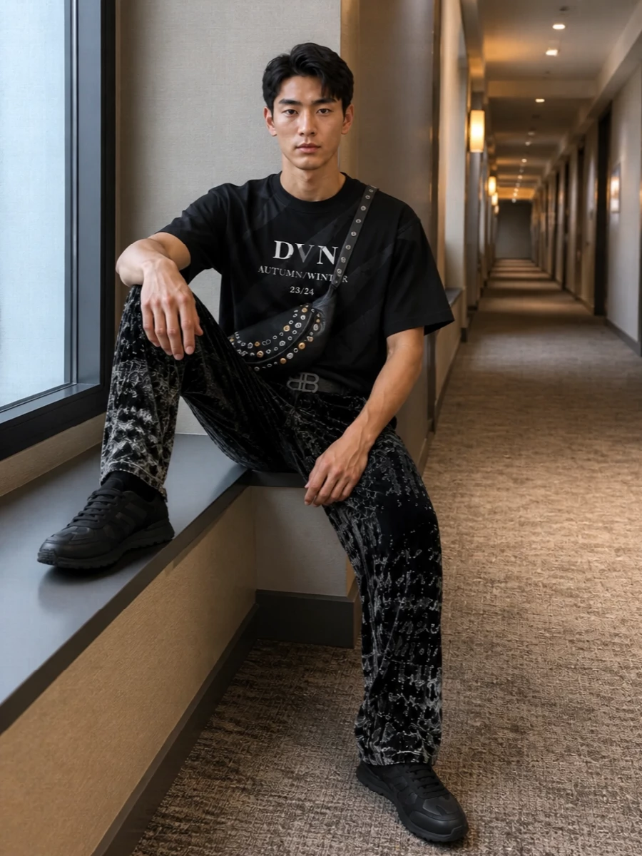 A dark, graphic base keeps the focus on the velvet Diesel trouser, with the Dries tee echoing its geometric energy in a more controlled way. Black-on-black runners ground the volume while the studded belt bag and slim belt bring just enough metal to feel night-out without tipping into costume.