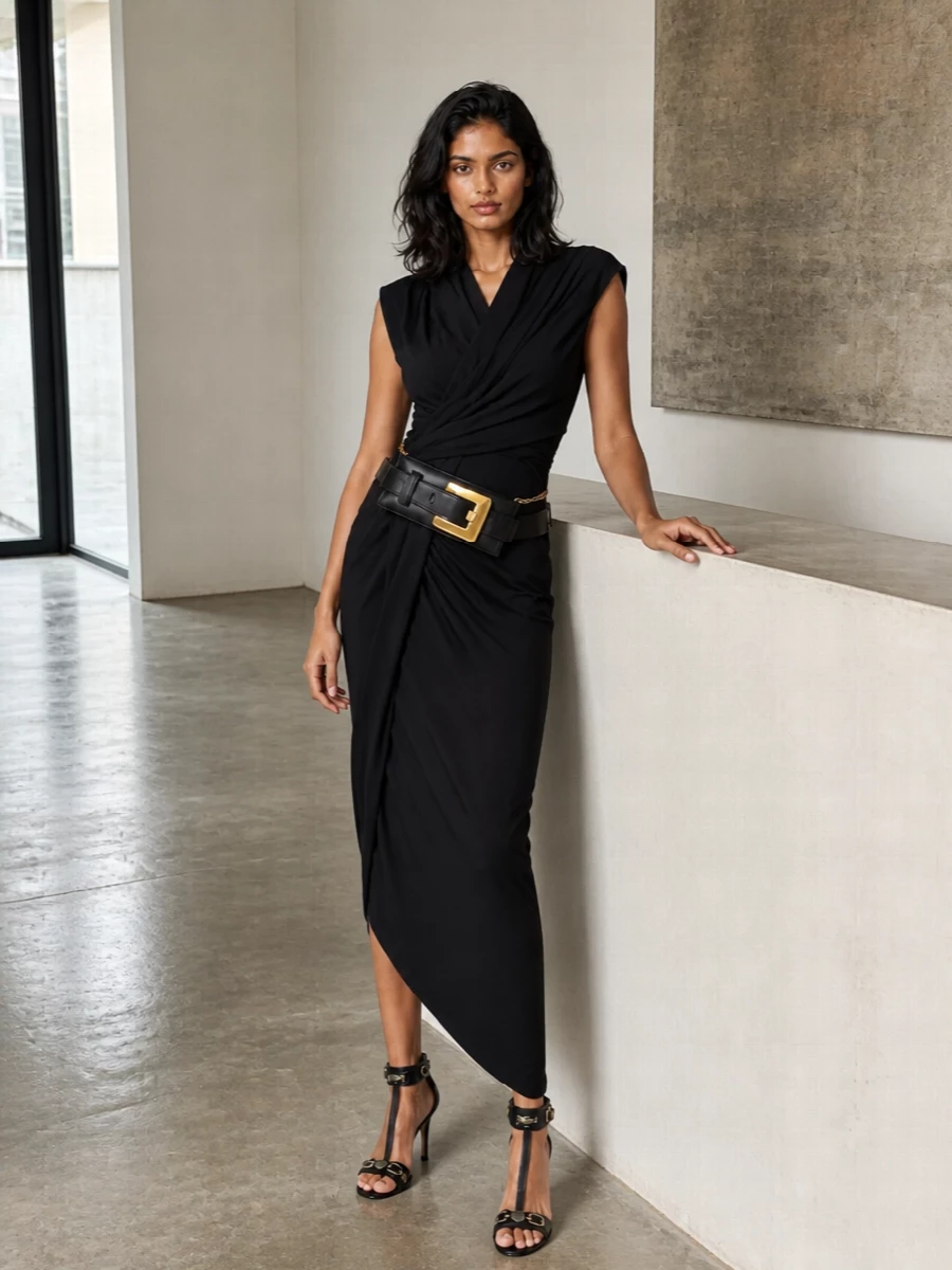 This pairing leans into Balenciaga’s architectural side, using the asymmetric black midi to echo the clutch’s long, sculpted line rather than breaking it with separates. The result is a sharp, column silhouette that lets the belt-clutch read like jewellery against clean black. High, hardware-detailed stilettos keep the mood unapologetically night-focused while maintaining a refined, fashion-forward formality.