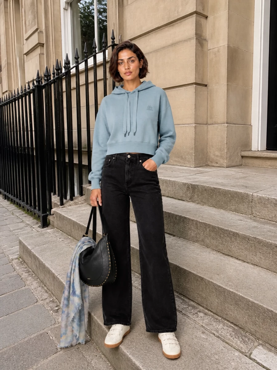Dusty blue and washed black keep the palette cool and understated, with the cropped hoodie meeting the high-rise wide leg in a relaxed, leg-lengthening line. Cream velcro sneakers and a studded black hobo add just enough contrast and texture, staying firmly in a clean, Parisian streetwear mood. The printed scarf brings a quiet hit of colour that connects the top half without breaking the simplicity.
