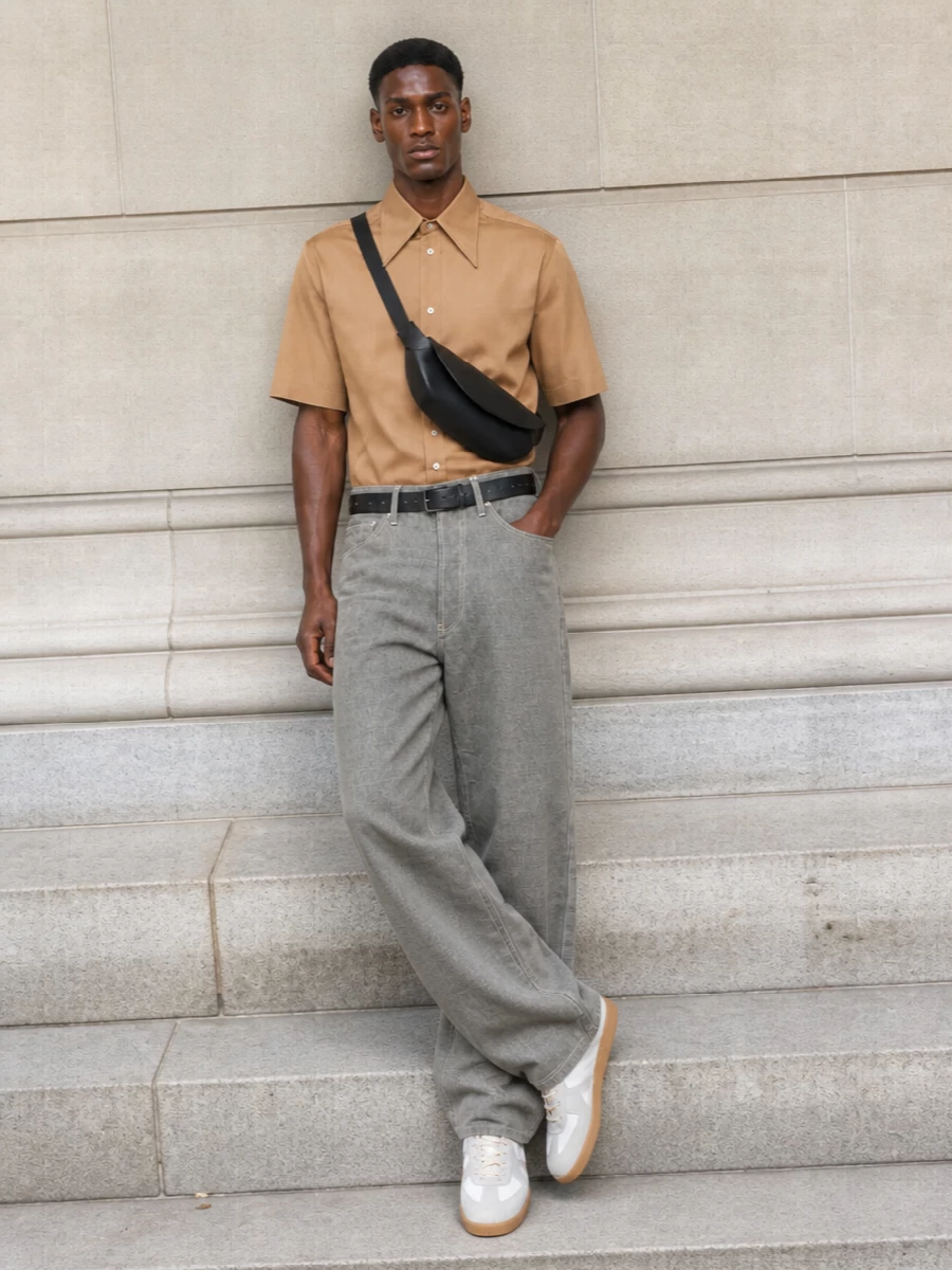 Camel shirting and stone wide leg tailoring create a calm, architectural base in warm and cool neutrals. Off white trainers keep it relaxed but precise, while a sculpted black shoulder bag adds just enough structure. The result is quietly assertive summer tailoring with subtle Margiela codes rather than overt detailing.