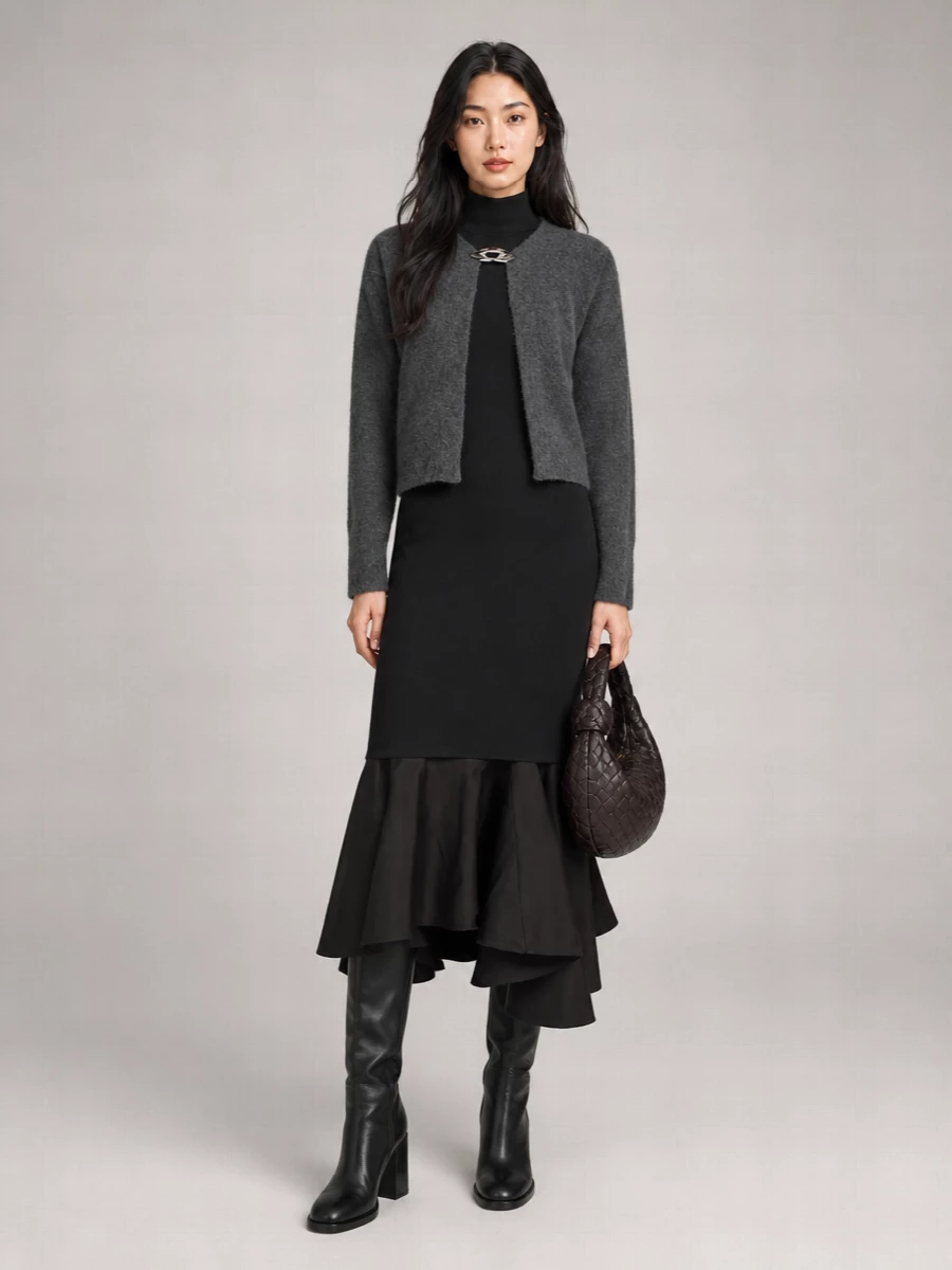 I chose the dress route to keep the cropped cardigan jacket the only tailoring note, sitting over a single dark knit column rather than competing with another jacket and trouser line. The black mock-neck midi dress, sleek knee boots and padded chocolate shoulder bag create a long, minimal silhouette in charcoal and deep neutrals that feels quietly powerful for cold-season evenings. Texture does the talking while the palette stays disciplined, so the silver clasp on the cardigan remains the sole glint of hardware up top.