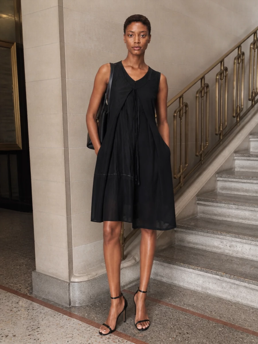 A deconstructed Margiela black dress paired with the Ferragamo tote creates a monochrome, quietly assertive city ensemble that moves easily from gallery openings to late dinners. The sharp Tom Ford stiletto keeps the silhouette clean and elongating while staying in the same discreetly luxurious register. Choosing the dress route over separates keeps the message focused and minimal, letting unusual construction and fine materials do the work rather than extra layers.