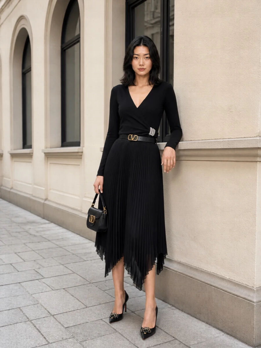 A study in noir romance, this outfit pairs the liquid pleated Valentino skirt with a crystal-ruched wrap knit that carves out a clean, sculpted waist. Jeweled pointed pumps and a sharp small flap shoulder bag keep the mood high-cocktail, with a slim VLogo belt tracing a single line of gold through the monochrome. The result is quietly dramatic, ideal for dinners, openings or any night that deserves movement and light-play without overt drama.