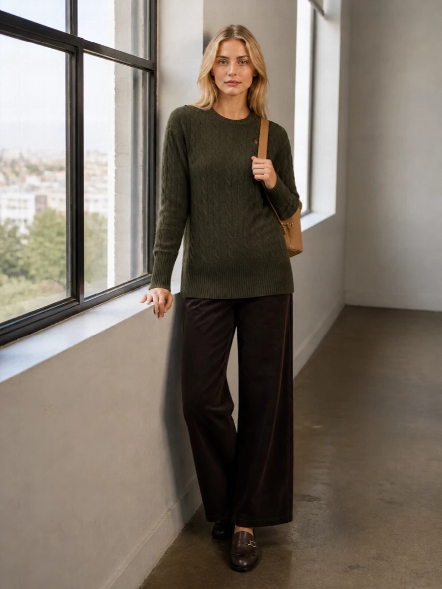 Olive cable knit meets deep chocolate corduroy for a collegiate, coffee-toned palette that feels polished without feeling stiff. The high-rise wide leg and longline jumper create an easy, lengthening column, sharpened by sleek fringed loafers. A structured camel backpack adds a subtle campus nod and keeps the whole outfit quietly composed for city days.
