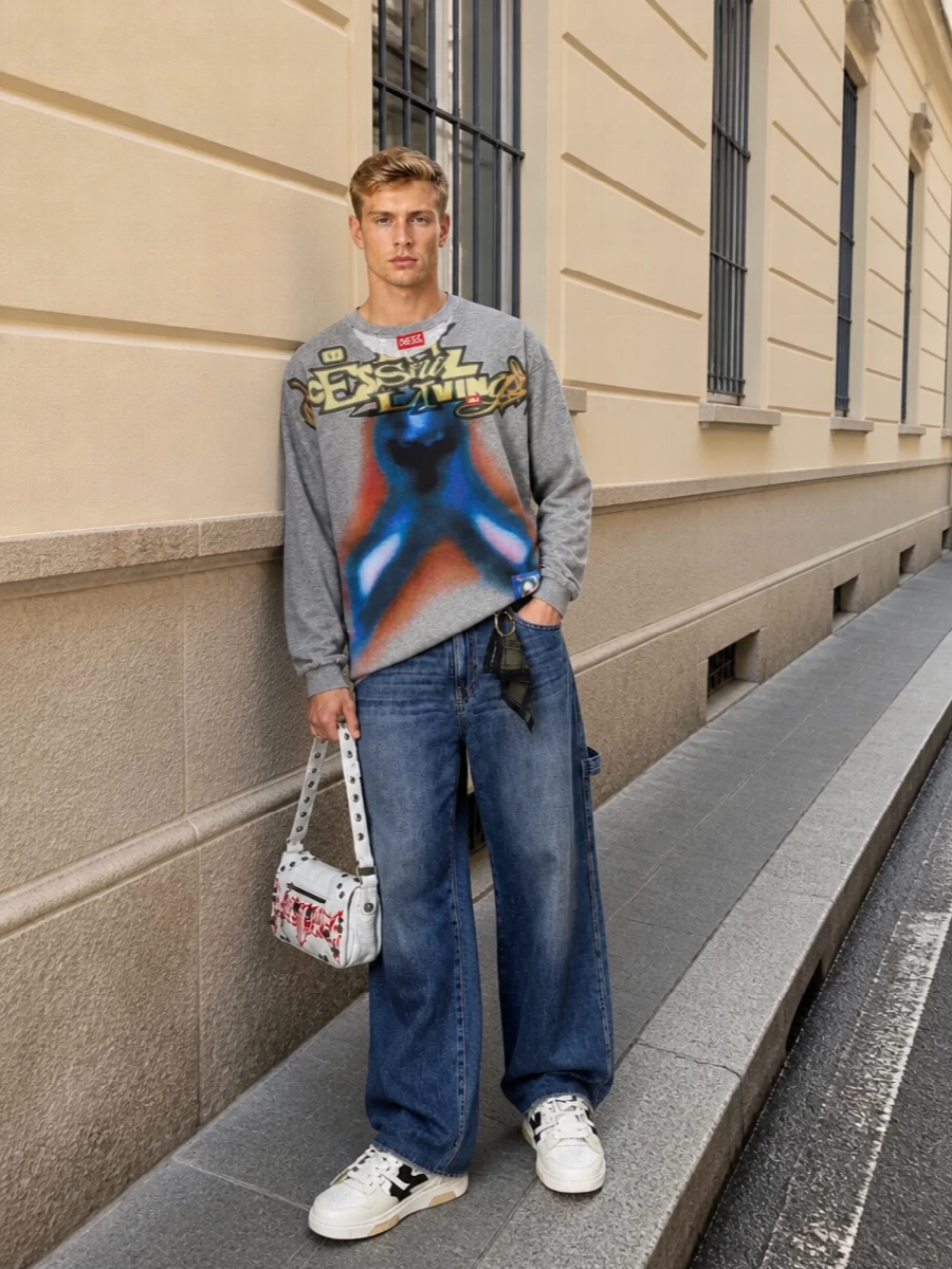 The heather-grey Diesel graphic tee sits over relaxed Darkpark wide-leg denim for a laid-back, early-2000s street feel that still reads intentional. Chunky Off-White sneakers keep the proportions grounded and sporty, while the Balenciaga shoulder bag injects a sharp hit of graphic attitude and ties the whole palette back to the tee’s bold artwork. It is an easy city uniform with a clear Y2K storyline and a premium streetwear mix of labels.