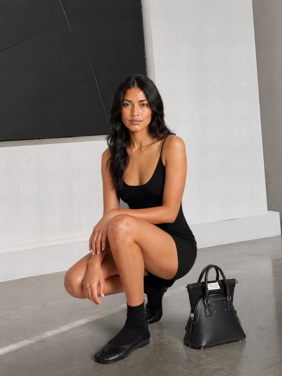 I chose the dress path so the tabi socks and ballerinas can frame bare leg with a clean, graphic line rather than compete with trousers. The black slip mini, iconic Tabi flats and structured trapeze bag read as a precise Margiela evening uniform, quietly subversive but easy to wear. It is all about a tight black palette, sharp geometry and subtle house signatures doing the work up close.