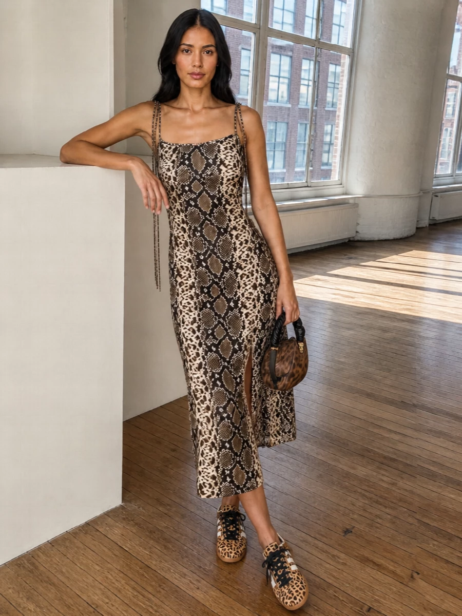 Acne’s brown snake-print slip dress and the twisted-handle Ganni bag create a rich, animal-textured story in the same warm chocolate family, reading downtown and directional rather than overtly glam. The slim midi cut plus sneakers keeps it easy and street-led, but the print and silhouette are strong enough to move straight into late-night bars. I chose the dress route over separates so the bag’s sculpted shape and pattern remain the focal point, with a clean, uninterrupted column underneath.