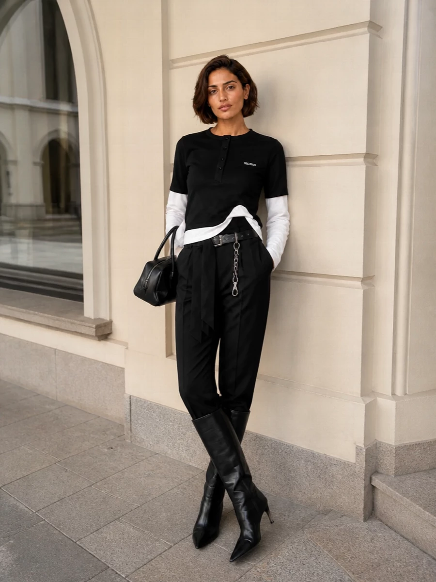 A monochrome Attico uniform that leans sporty without losing its edge. The layered henley body and sculpted high-rise trousers create a clean, long line, sharpened by pointed knee boots and a structured mini bag. Silver hardware and a single chain belt detail echo through the styling for a tight, intentional finish that works from coffee runs to late-night bars.