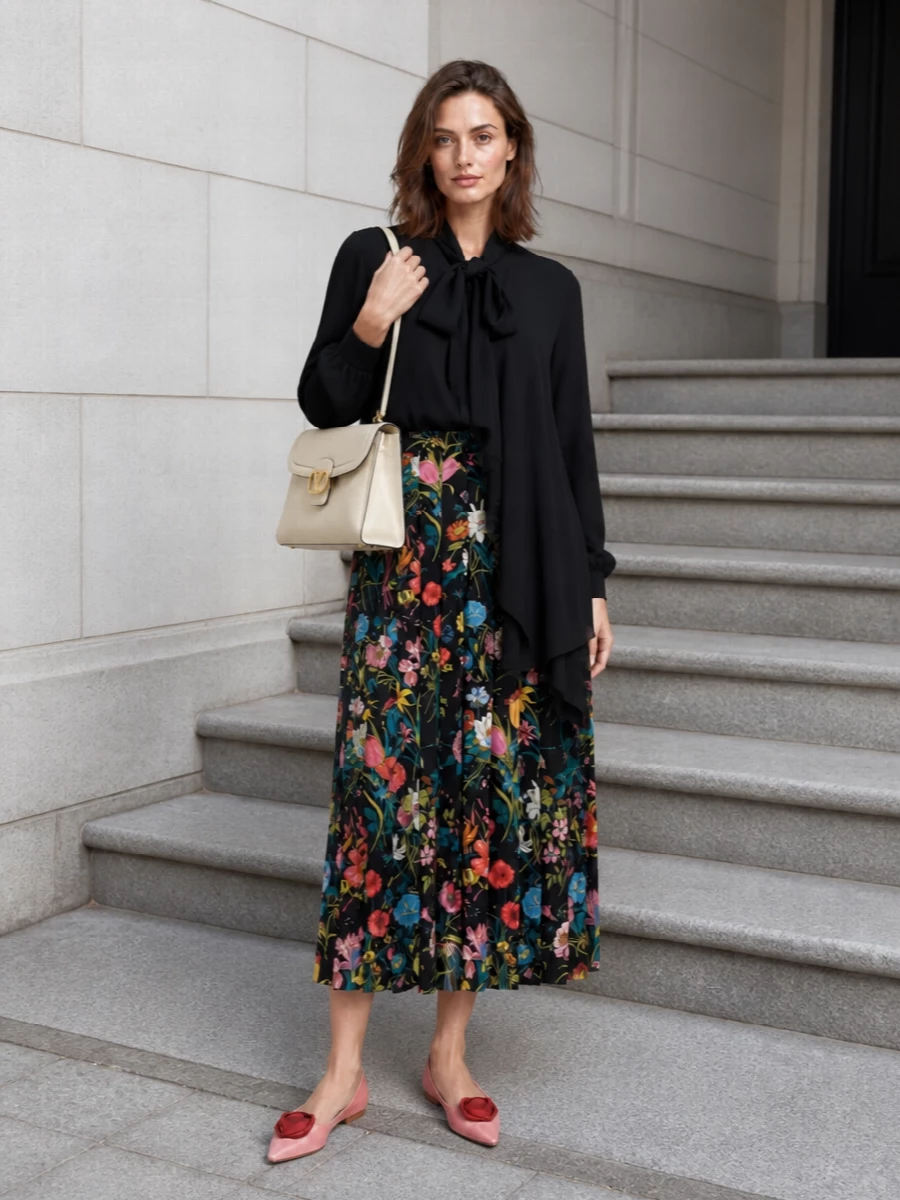 A dark romantic base meets quiet structure: the inky Gucci floral skirt is grounded by Balenciaga’s black bow-draped blouse for a polished, print-focused silhouette. Soft rose flats and a buttercream top handle keep the palette refined, picking up the skirt’s warmer blooms and introducing just enough preppy charm. The result is an elegant day-to-dinner ensemble that feels sophisticated without tipping into fussiness.