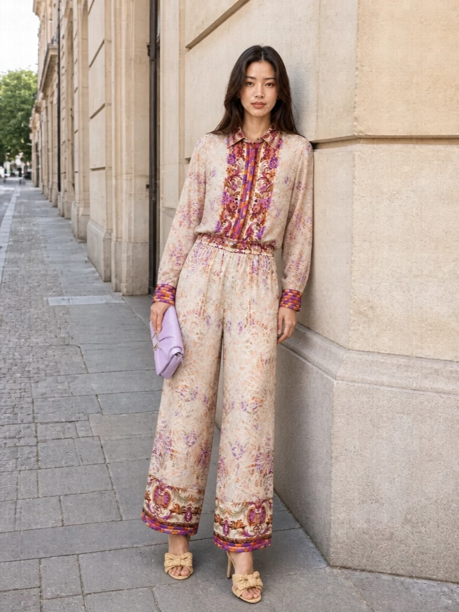 A romantic, print-on-print Pierre Louis Mascia pairing that reads like a softly tailored set, the baroque shirt and matching wide-leg trouser create one continuous, painterly column. Neutral raffia heels keep the silhouette light for warm evenings, while the lilac clutch quietly picks up the orchid tones for cocktails or gallery nights. Wrap the coordinating scarf loosely at the shoulders or knot it to your bag when you want an extra touch of drama without more structure.