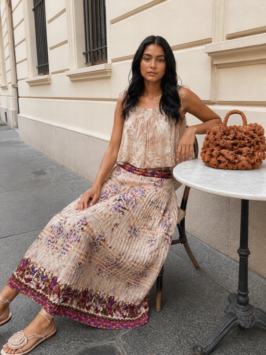 A softly pleated palm-print camisole in sand lets the Pierre Louise Mascia maxi skirt take center stage, keeping the romance light and modern. Neutral rose-detailed sandals and a sculpted raffia top-handle bag continue the boho mood without fighting the print. The matching triangular scarf finishes the story with a whisper of coordinated color and movement for late-afternoon terraces and warm, dressy dinners.