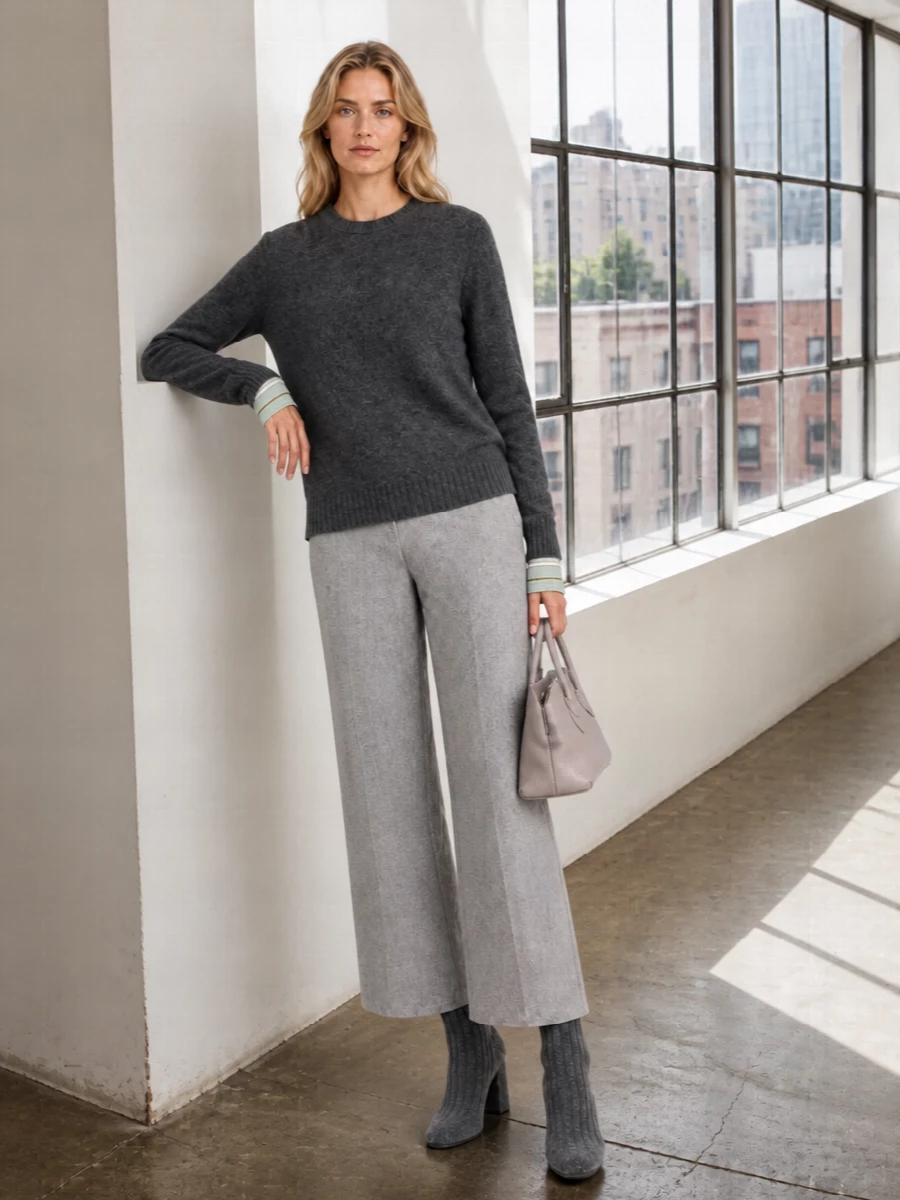 Charcoal and heather greys sit in quiet conversation here, the knit grounded by precise wide-leg tailoring rather than loungewear. The ribbed sock boots extend that vertical line, while a compact grey top-handle keeps the mood polished and unfussy. It is an easy weekday uniform for someone who likes their knits to read as considered as their trousers.