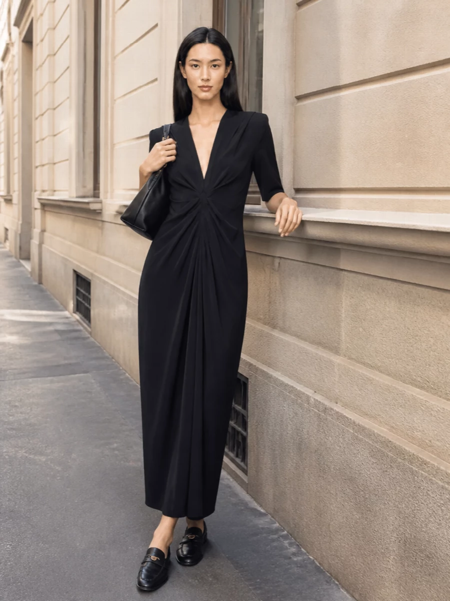 I’m anchoring this with the dress route so the shoes read intentionally refined rather than too corporate, using a sculpted black midi that mirrors their quiet structure. The pleated waist and V-neck give just enough architecture to balance the low block heel, keeping the silhouette long and composed. A sleek black shoulder bag with discreet gold hardware ties back to the loafer’s heart detail for a cohesive, city-ready evening ensemble.