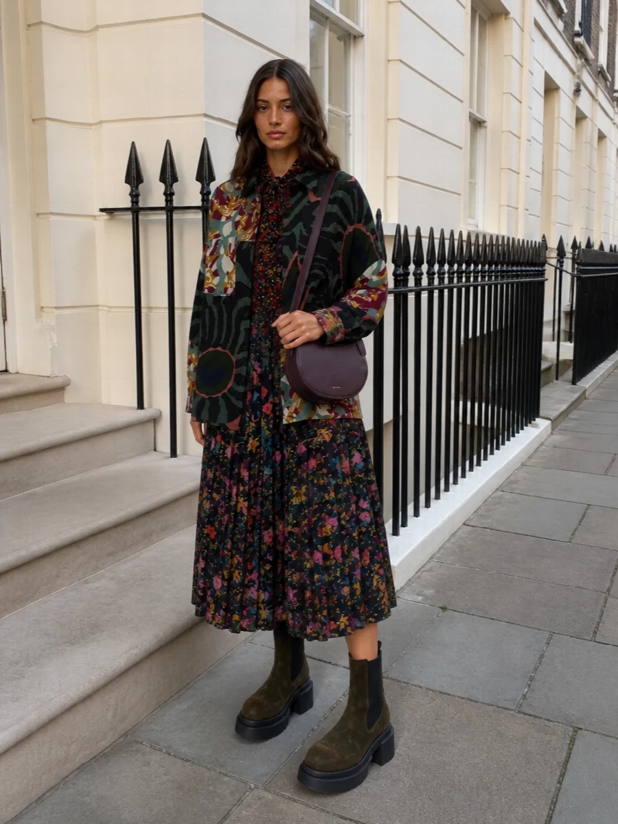 I am styling the Dries shirt-jacket over the Gucci floral midi dress, skipping separate top and bottom to let one fluid base anchor the print story. The result is a romantic, slightly boho composition in deep greens, burgundies and inky black, grounded by moss Rick Owens platforms so it feels urban and modern rather than nostalgic. A sculpted plum crossbody adds quiet structure and polish while staying in the same rich, autumnal spectrum.