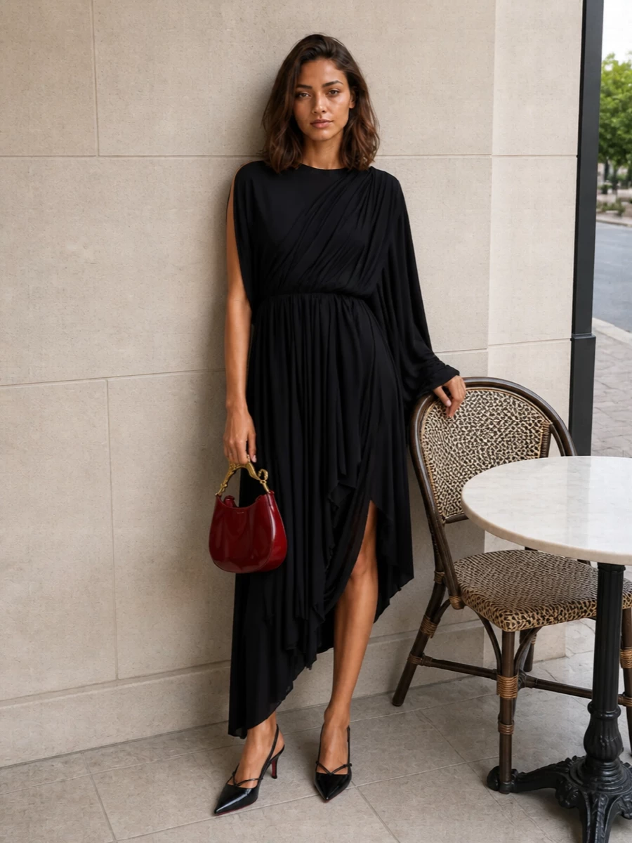 Anchoring the outfit with the draped black Balenciaga midi keeps the mood sculptural and pared back, allowing the oxblood Lanvin bag’s gold feline handle to take center stage. The Louboutin kitten slingbacks extend the clean, elongated line without shouting, so the interplay of deep red, black, and gold reads quietly decadent and very evening-focused. Choosing the dress route over separates here preserves a single, fluid column that best matches the bag’s couture-leaning drama and formality.