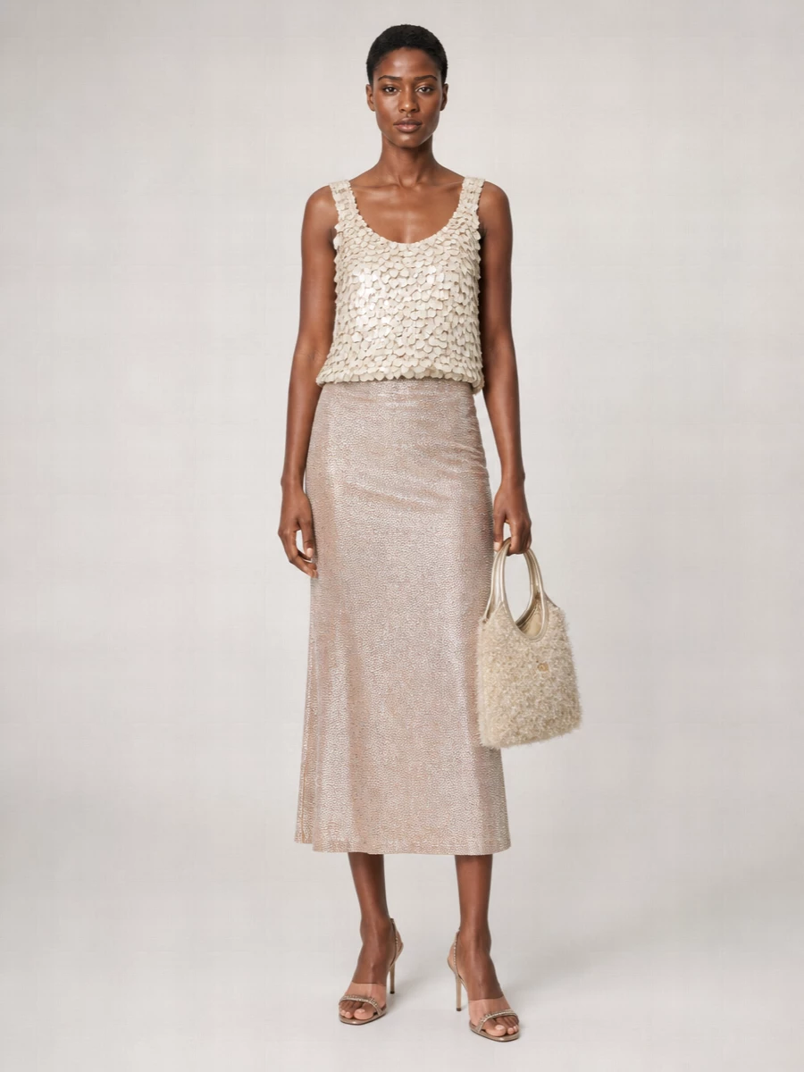 A full champagne story, this pairing turns the sequin tank into a soft column with the metallic midi rather than a loud two-piece. Rose-bronze heels and a fuzzy champagne-gold mini tote keep everything in a warm, romantic register that feels club-ready but still grown-up. The proportions stay long and lean, letting the texture and light-play do the work.