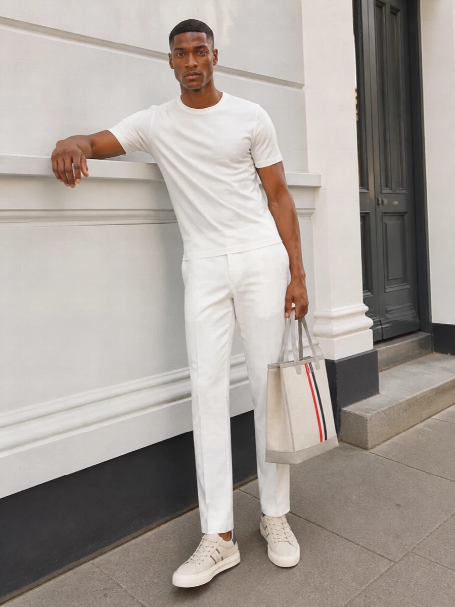 A soft white Zegna tee meets crisp off white Thom Browne tailoring for a clean, tonal base that feels relaxed yet precise. Light taupe Hogan sneakers and the structured Thom Browne tote keep the mood polished but easy, ideal for warm city days where subtle detail does the work.