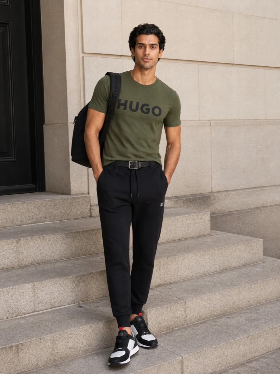 Olive and black keep this Hugo set clean and unfussy, with the logo tee grounded by tapered joggers for a focused, athletic base. The white and black runners brighten the palette just enough, while the streamlined backpack and slim belt give a polished edge that still feels relaxed. It is an easy city uniform that moves from gym commute to weekend errands without a change.