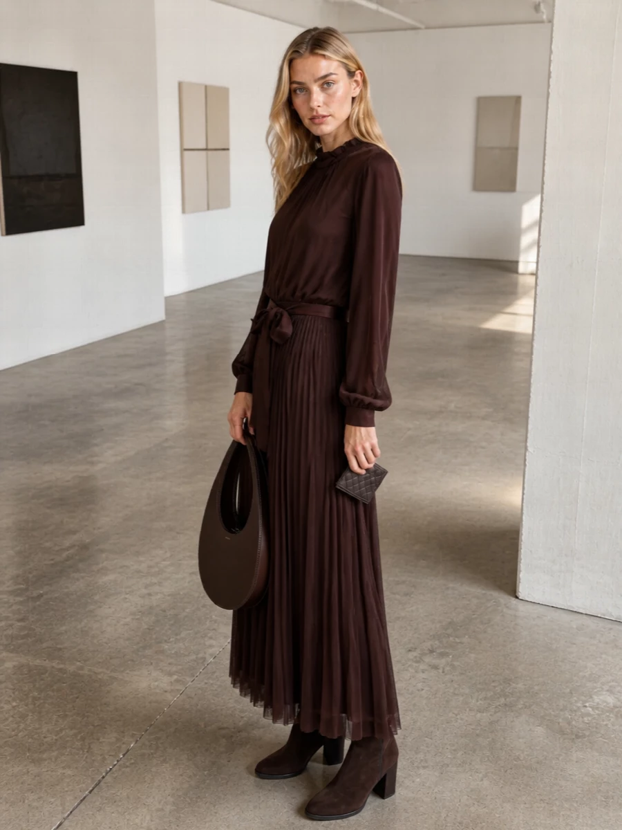 The chocolate Forte Forte dress, suede Chelsea boots and sculptural Coperni tote create a single, tonal column of brown that feels serene, grown-up and discreetly luxurious. Opting for the dress route keeps the focus on fluid movement and texture, which harmonises better with the slim woven cardholder than a more segmented top and trouser pairing. The result is an evening-ready ensemble that is rich in depth yet restrained in branding, ideal for gallery dinners or intimate winter events.
