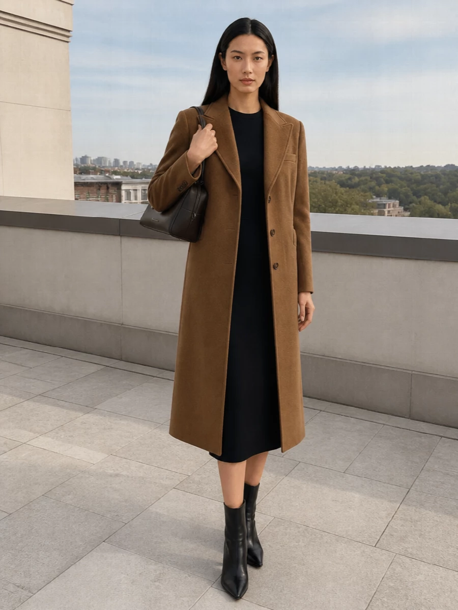 I chose the dress route to let the camel coat sit as a clean, authoritative outer layer over a single, uninterrupted column of navy, which keeps the mood tailored and quietly powerful. The pointed black ankle boot and structured espresso top-handle bag sharpen the palette and reinforce the long, vertical silhouette, giving you a boardroom-to-restaurant uniform that feels composed without being severe. This is refined Italian-style suiting energy, translated into a streamlined coat, sheath and accessories story in camel, navy and deep brown.