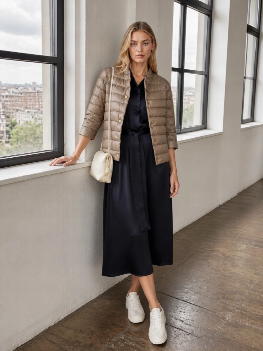 I chose the dress route rather than tailoring, as the satin shirt dress creates a single, clean column under the boxy quilted Herno jacket, keeping the mood minimal and softly polished. Ink navy, taupe and buttercream stay within a muted, city-ready palette, while low-top sneakers and a small neutral shoulder bag keep the wrap-and-go ease that suits warm-weather days that run into dinner.