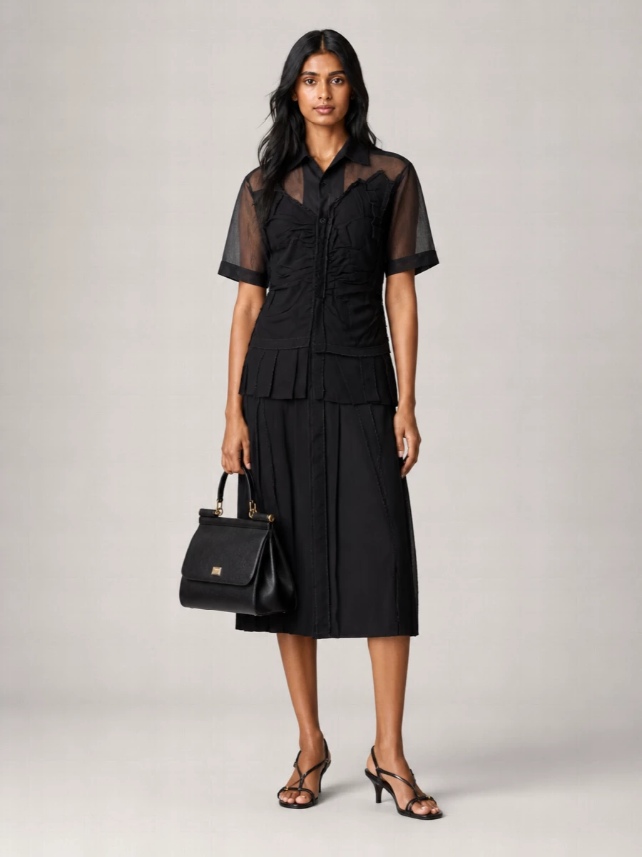 The Margiela sheer-panel shirt dress and Miu Miu kitten-heel slingbacks create a precise black column with subtle transparency and fine gold touches, in step with the Dolce&Gabbana bag’s polished structure. I chose the dress route rather than separates to keep the line clean and uninterrupted, letting the bag’s shape and hardware read as the focal tailored accent.