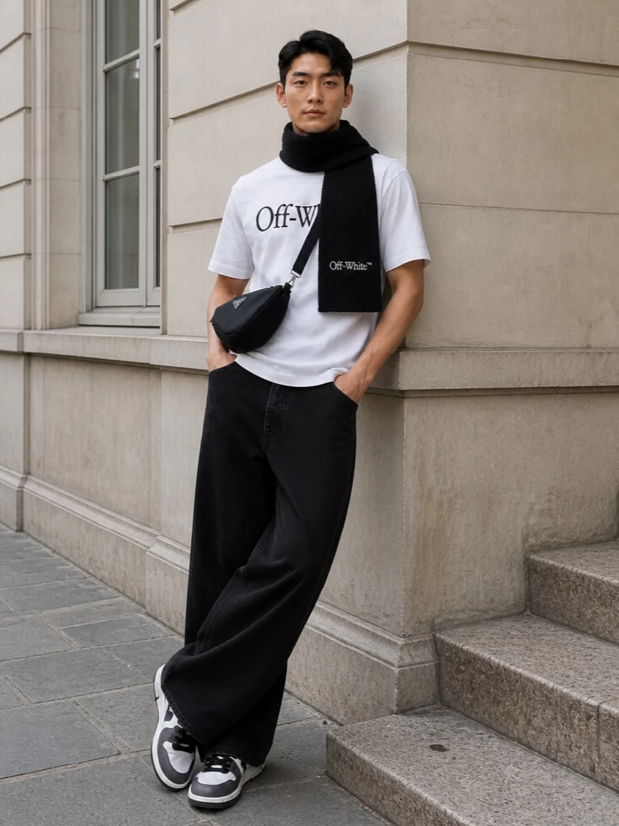 This look builds a sharp monochrome street uniform around the Off-White tee, grounding it with washed-black wide-leg denim for a clean, runway-lean silhouette. White-and-charcoal court sneakers keep things graphic but refined, while the Prada crossbody and Off-White scarf introduce quiet luxury and texture without diluting the minimal, logo-driven attitude. It’s an easy, daily FW formula that feels considered from every angle.