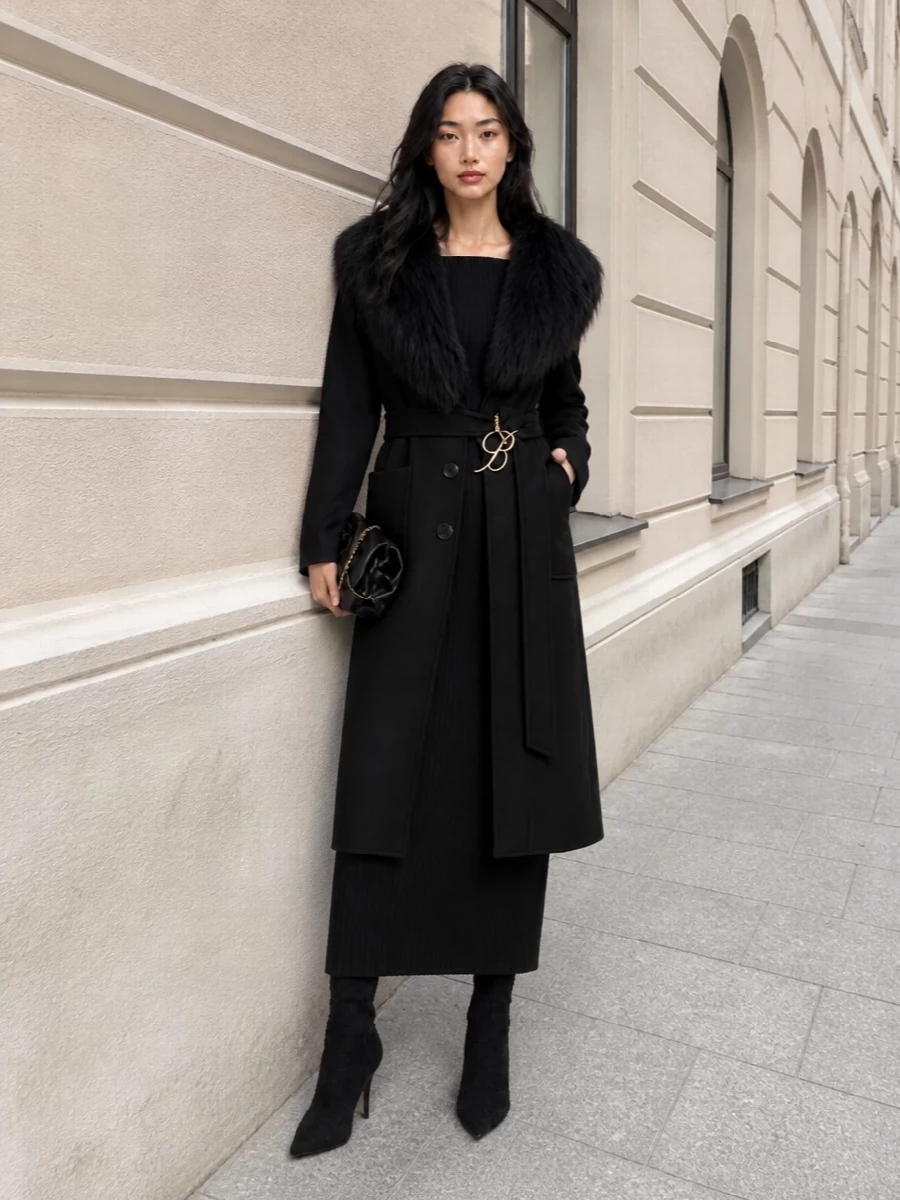 I am styling this as a dress-focused evening ensemble, because the coat wants one continuous, sculpted line rather than a segmented blazer and trouser story underneath. The off-shoulder knit maxi, sharp knee boots and soft sculpted clutch let the Blumarine coat’s fur collar and belt remain the main event while keeping the whole composition firmly in the romantic, tailored, quiet-luxury space. Head-to-toe black, with just a trace of gold hardware, feels modern and powerful without diluting the coat’s drama.