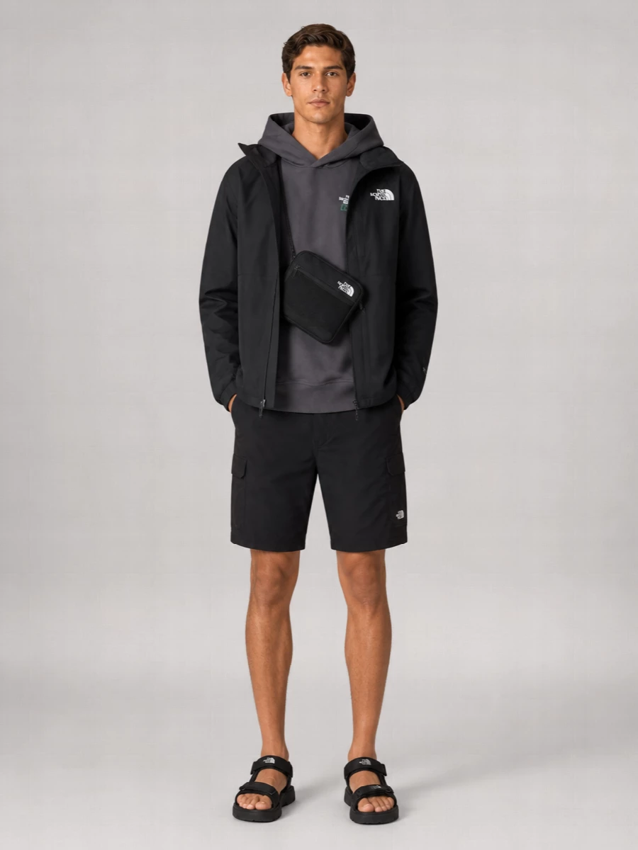 A monochrome The North Face set that leans into technical streetwear for warm days, pairing a clean black shell with a charcoal logo hoodie. Mid‑thigh cargo shorts and strappy sport sandals keep it agile and ventilated, while the crossbody bag adds just enough function without crowding the silhouette. It feels ready for city miles, travel days or spontaneous hikes where comfort and utility need to align.
