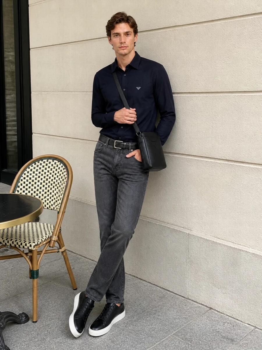 Charcoal straight-leg denim and a fluid navy shirt create a low-contrast, quietly refined base that feels considered without trying too hard. Black leather sneakers keep it modern and adaptable from smart office days to late dinners, while the slim crossbody and belt echo the dark accents for a clean, city-ready finish.