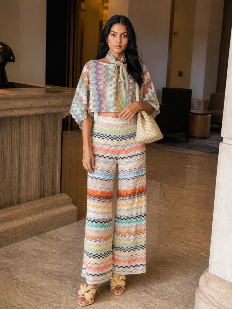 Cropped chevron on top and sun-faded chevron through the wide-leg trouser create a head-to-toe Missoni moment that feels breezy yet considered. Nude raffia heels and a structured woven top handle keep all that color grounded in soft neutrals. A washed floral scarf in sage and blush adds just a whisper of romance around the neckline or tied to the bag.