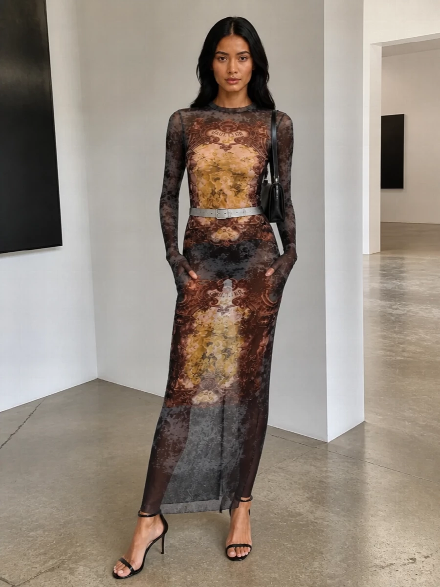 A sheer Gaultier maxi does all the talking here, treated like a graphic second skin for late-night city floors. Barely-there black stilettos and a slick Courrèges shoulder bag keep the line long and clean, while a slim metallic belt quietly traces the waist. The result is nocturnal, body-conscious and sharply modern, with all the drama contained in the print and proportion.