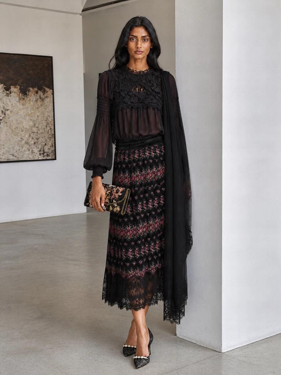 A study in dark romance, this outfit layers sheer plum lace with a softly pleated black floral midi for movement that feels cinematic but still precise. Lace-detailed pumps and an embroidered clutch continue the play of transparency and texture, keeping everything in a rich, moody palette for evening. The result is feminine and dramatic, yet balanced enough for cocktails, gallery nights or dressy dinners.