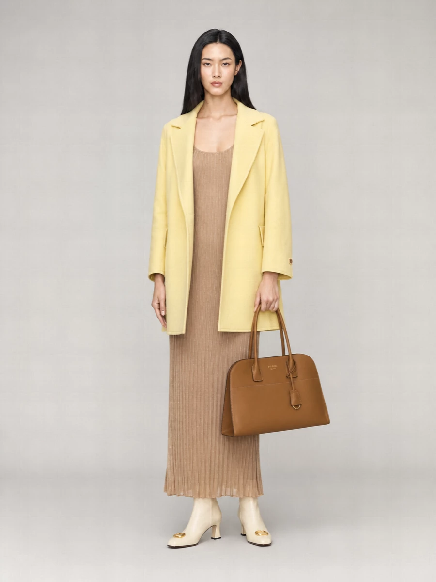 I chose the dress route to keep the yellow Max Mara coat clean and uninterrupted, letting it frame one long, neutral column rather than competing with a second tailored layer. The camel ribbed maxi, cream boots and tan top-handle bag create a warm, tonal story that feels polished enough for client lunches yet soft enough for evening reservations. The result is quietly confident, with color used as a gentle highlight instead of a statement.“