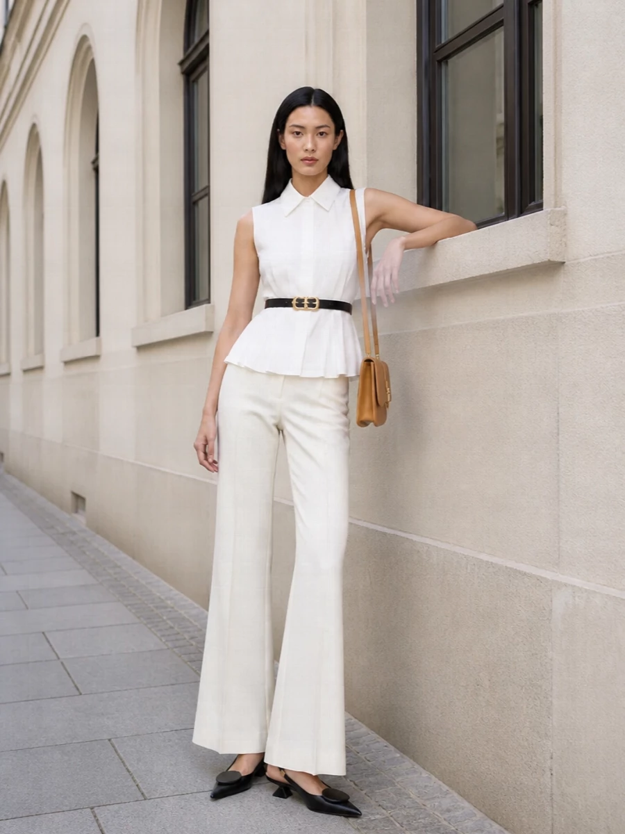 Sportmax’s ivory flared trouser is paired with a crisp, sleeveless peplum shirt to create a long, clean column with a softly defined waist—refined, architectural, and perfectly SS-ready. A sculptural black-and-nude Jacquemus slingback and slim camel cross-body introduce subtle contrast and warmth, while a fine Ferragamo belt quietly sharpens the waistline and echoes the dark accents for a cohesive, quietly luxurious evening look.