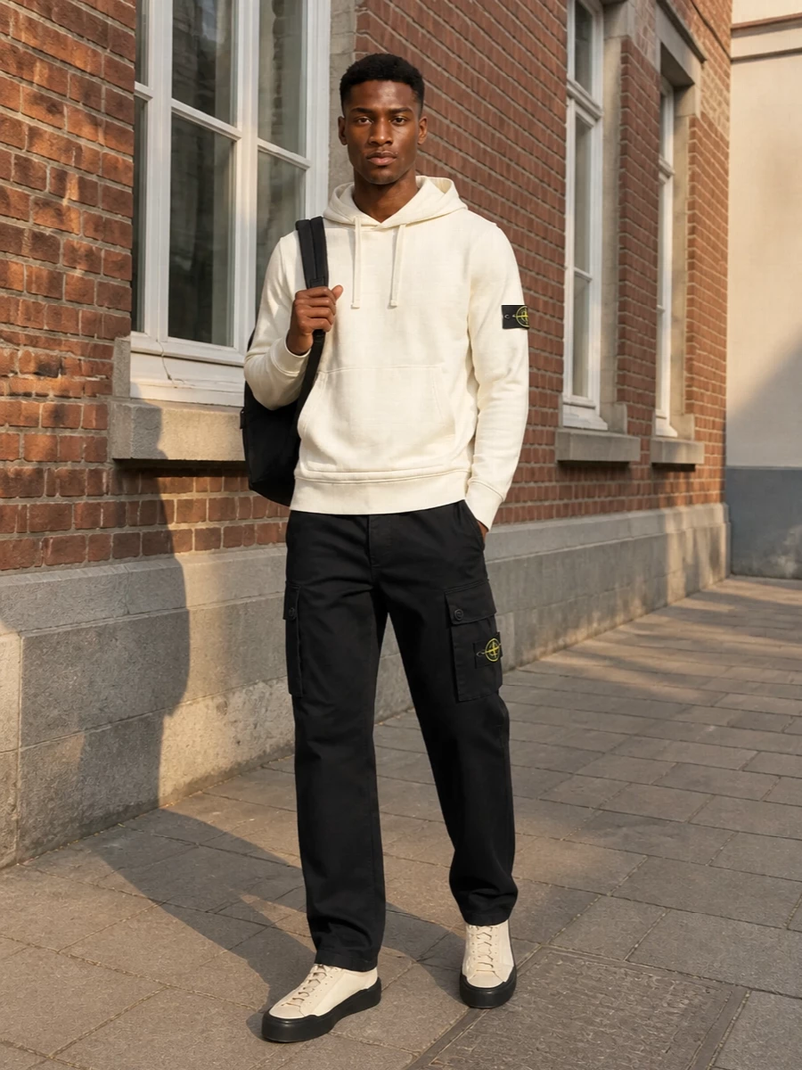 Off white up top and deep black through the cargos creates a clean, graphic Stone Island uniform, with the matching acid lime patches giving a subtle, considered hit of color. The straight-leg cargo line and streamlined low-top sneaker keep the silhouette sharp but relaxed, ideal for days that move from coffee runs to late city evenings. A black technical backpack finishes it with quiet, functional polish that feels true to the brand’s street-sport DNA.